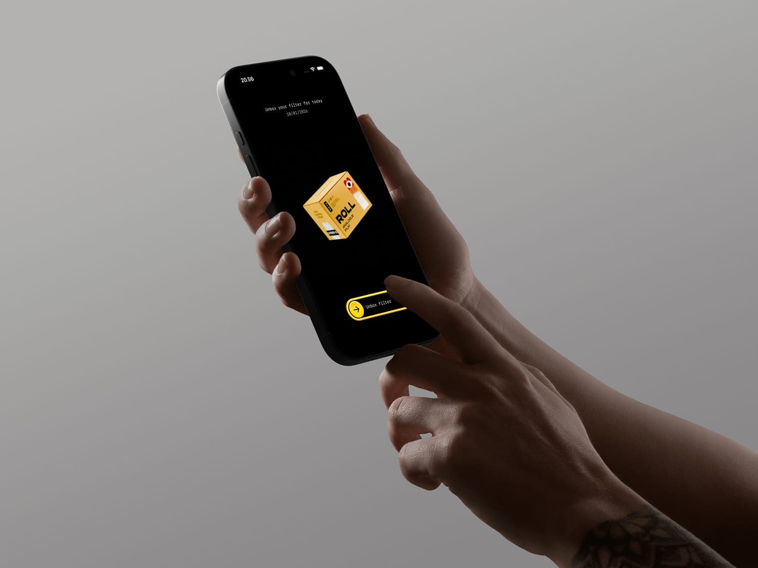 Hands holding a phone showing the Roll unbox screen — “Unbox your filter for today” with a yellow film box and Unbox filter button